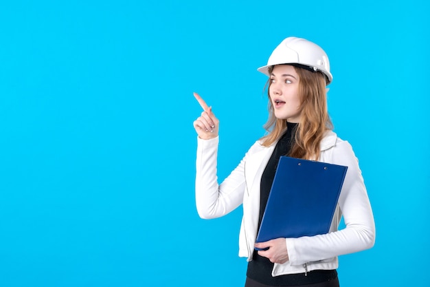 Front view female architect in white helmet on blue