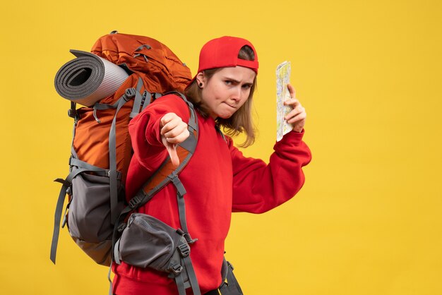 Front view female backpacker holding travel map making thumb down