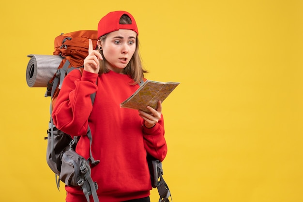 アイデアや質問で驚くべき旅行マップを保持している正面図の女性のバックパッカー
