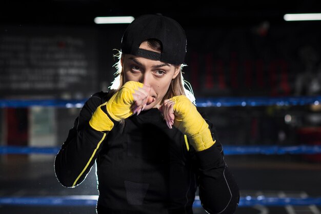 Front view of female boxer posing in the ring