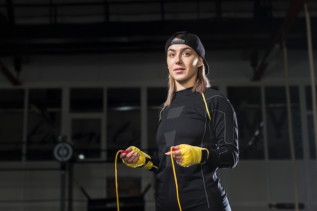 Front view of female boxer with protective glove and jump rope