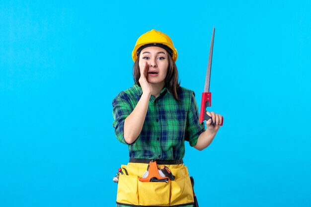 Front view female builder holding little saw