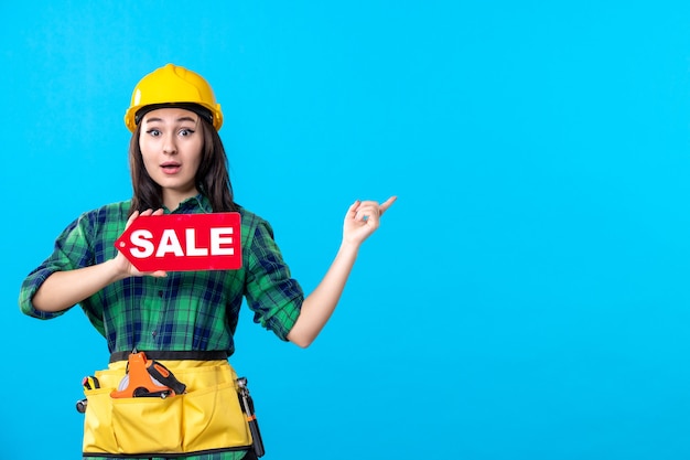 Front view female builder holding red sale writing on blue
