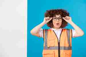 Free photo front view of female builder in uniform on the blue wall