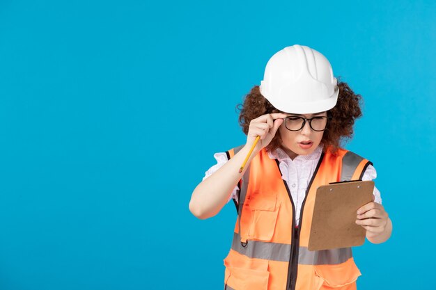 Front view female builder in uniform on blue 