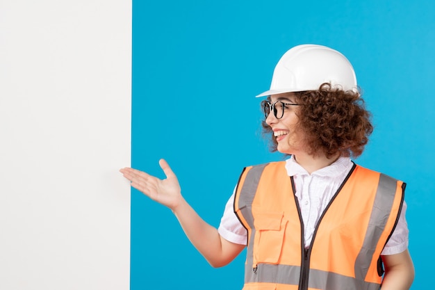 Front view female builder in uniform on blue 