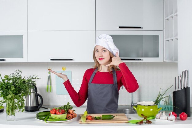 Front view female chef in apron making call me gesture