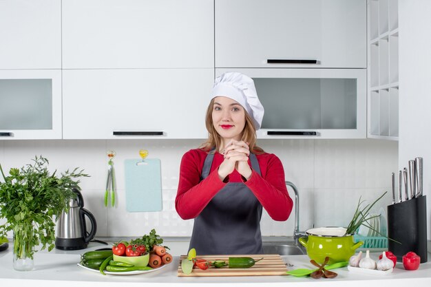 Front view female chef in cook hat holding hands together