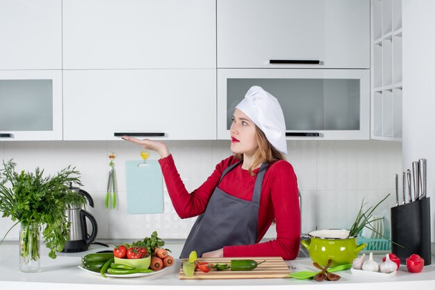 Front view female chef in cook hat looking at left