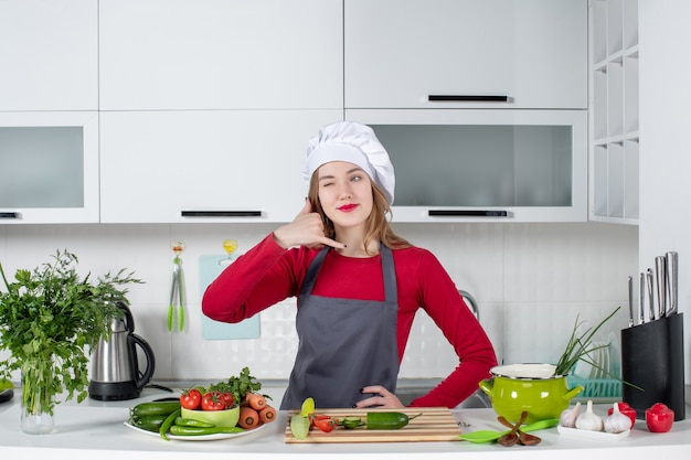 Front view female chef in cook hat making call me gesture