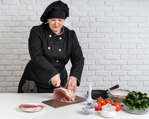 肉を切る女性シェフの正面図