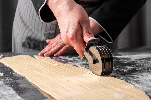 Free photo front view of female chef cutting though into strips