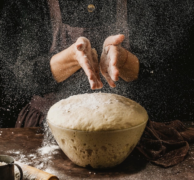 ピザ生地を扱う前に小麦粉を手にまぶした女性シェフの正面図