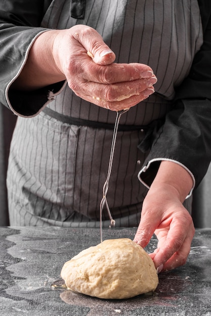 Front view of female chef kneading dough