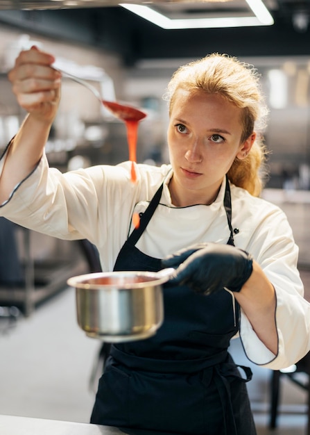 Front view of female chef preparing sauce