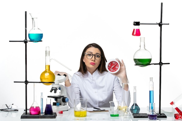 Вид спереди женщина-химик в белом медицинском костюме с часами на светлом белом фоне лаборатория научного вируса covid- пандемия