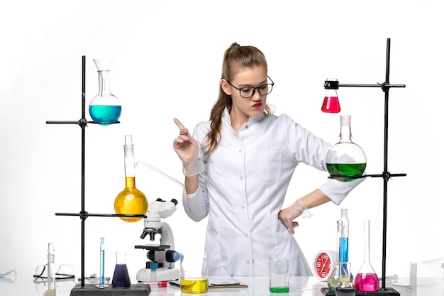 흰색 책상 화학 유행성 코로나 바이러스에 대한 솔루션 작업 과정에서 의료 소송에서 전면보기 여성 화학자