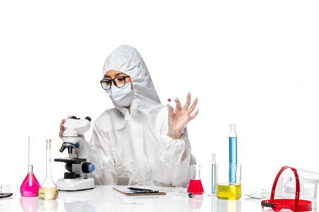 特別な防護服を着た女性化学者の正面図白い背景の化学コビパンデミック健康ウイルスのサンプルをチェック