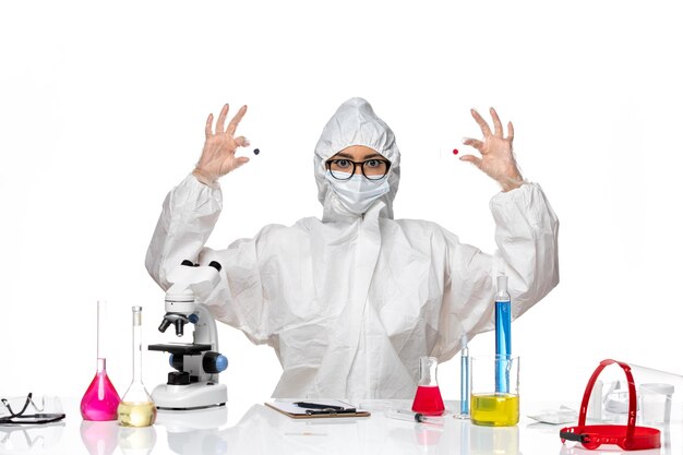 Вид спереди женщина-химик в специальном защитном костюме, держащая образцы на белом фоне, вирусная химия, пандемия здоровья