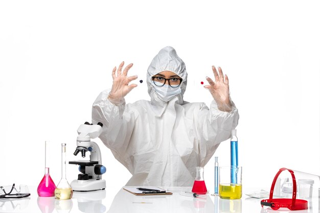 흰색 책상 바이러스 화학 covid 유행병 건강에 샘플을 들고 특수 보호 복에 전면보기 여성 화학자