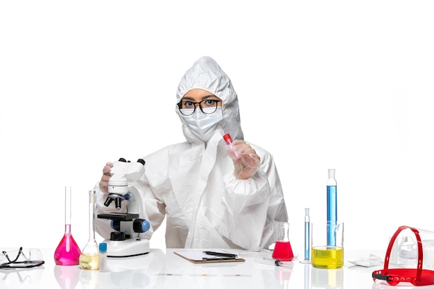 Front view female chemist in special protective suit just sitting on white background virus health chemistry covid-