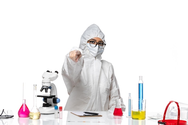 흰색 배경 covid- 화학 바이러스 실험실에 가리키는 특수 보호 복에 전면보기 여성 화학자