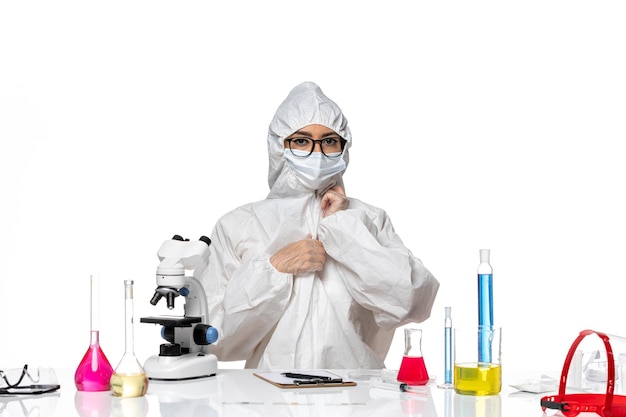 Front view female chemist in special protective suit posing on the white background chemistry covid- health virus