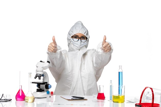 Front view female chemist in special protective suit smiling on white background covid- chemistry virus lab