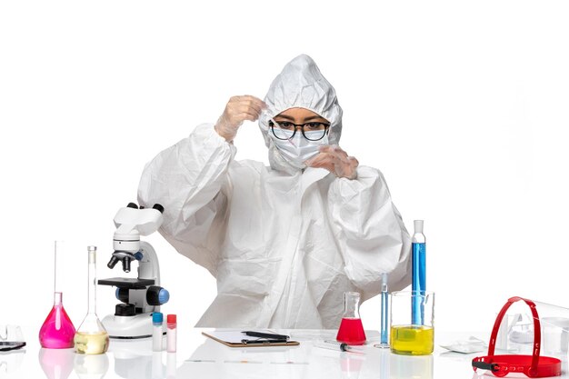 Front view female chemist in special protective suit working with solutions on white background virus covid chemistry lab
