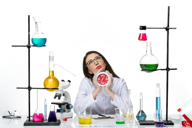 Вид спереди женщина-химик в белом медицинском костюме с часами на белом фоне лаборатория научного вируса пандемия covid