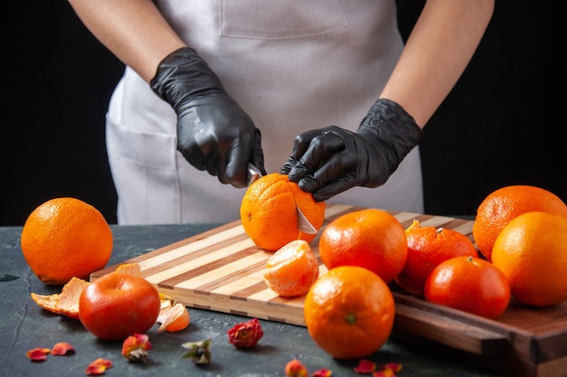 Front view female cook cutting orange on dark salad health meal food job vegetable fresh drink fruit diet