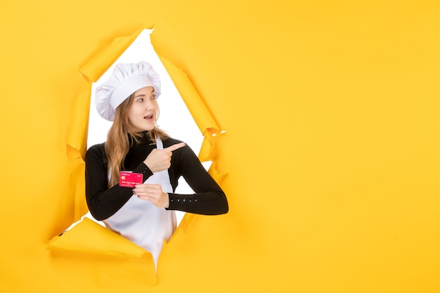 Cuoca vista frontale con carta di credito rossa su foto gialla emozioni cibo cucina cucina colore denaro lavoro