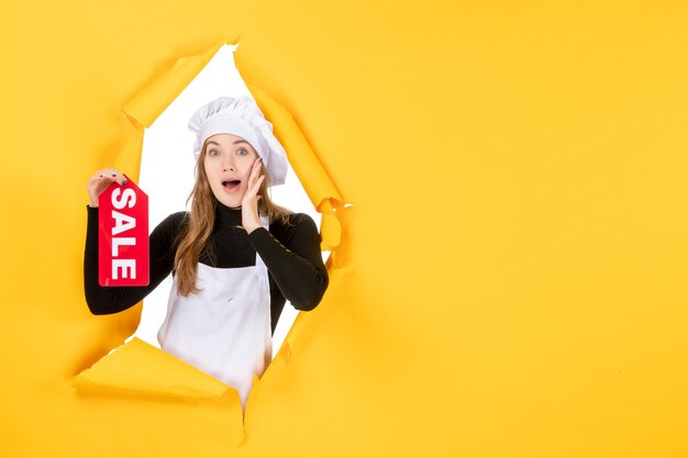 Free photo front view female cook holding red sale writing on the yellow color job kitchen emotion food photo cuisine