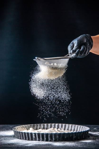 Front view female cook pouring white flour into the pan on the dark dough egg job bakery hotcake pastry kitchen cuisine