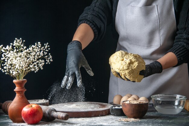 Front view female cook rolling out dough on dark job dough pie oven pastry kitchen hotcake cuisine bakery eggs