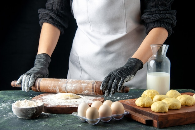 正面図女性料理人がダークケーキジョブオーブンで小麦粉と生地をロールアウトホットケーキ生地焼きパイ卵料理