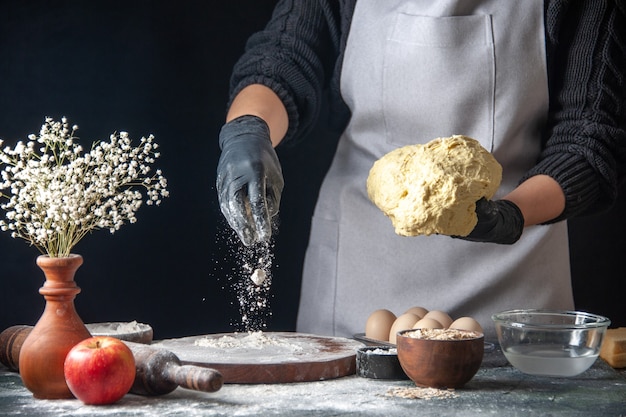 無料写真 正面図女性料理人が暗い仕事で小麦粉と生地を広げている生地ペストリーキッチンホットケーキ料理ベーカリー卵