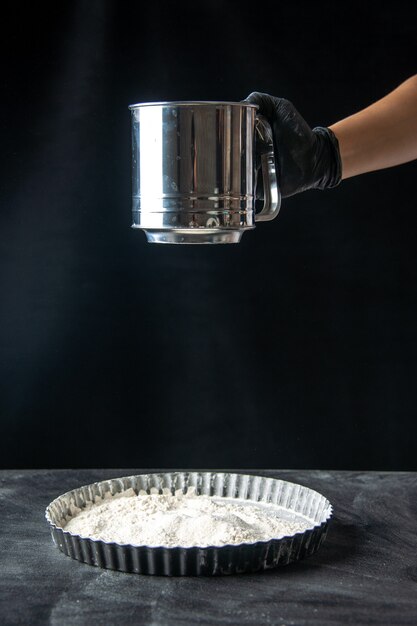 Front view female cook sowing white flour into pan on dark egg cake cuisine pie bakery worker job