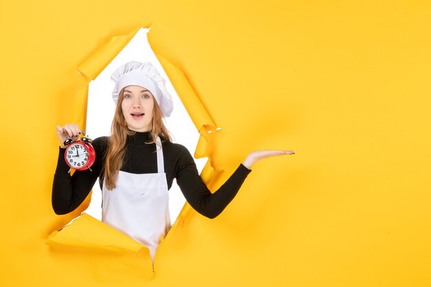 노란색 사진 색상 작업 감정 요리 부엌 태양에 시계를 들고 흰색 요리사 모자에 전면 보기 여성 요리사