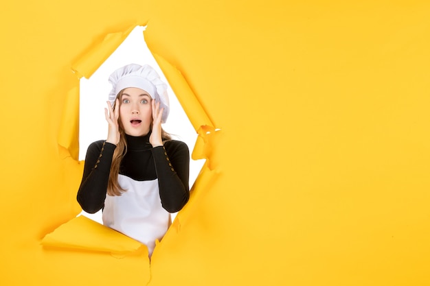 Cuoco femminile di vista frontale sul lavoro di carta fotografica della cucina del sole del cibo giallo