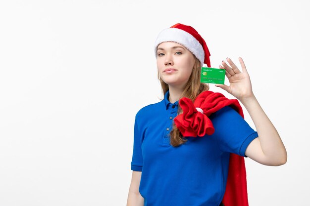 Front view of female courier holding bank card on white wall