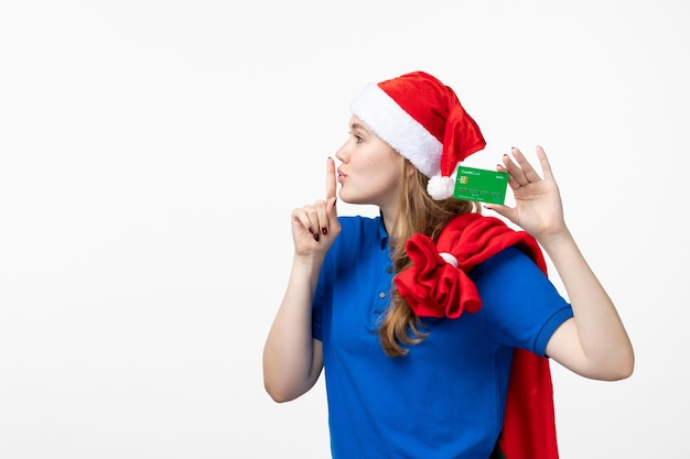 Front view of female courier holding bank card on white wall