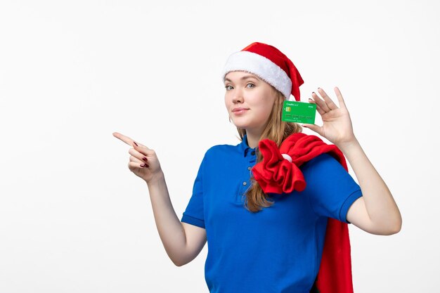 Front view of female courier holding bank card on white wall