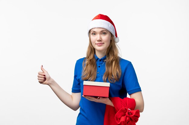 Front view of female courier holding holiday present on a white wall