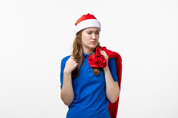 Front view of female courier holding present bag on a white wall