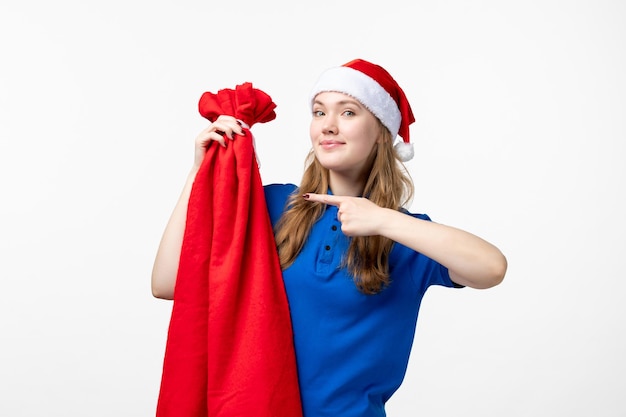 Front view of female courier holding present bag on a white wall