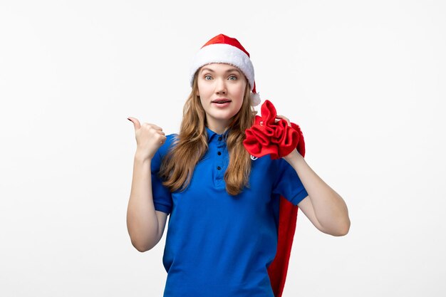 Front view of female courier holding present bag on white wall