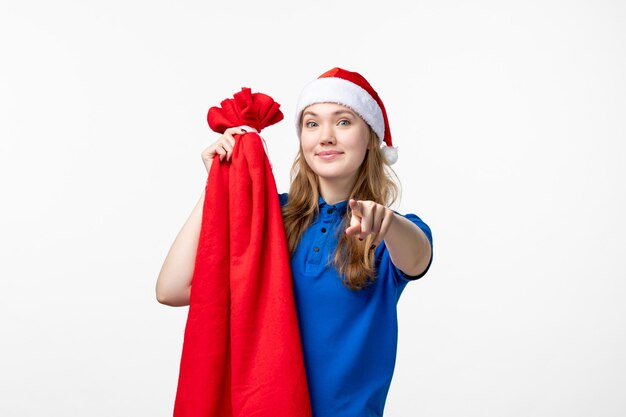 Front view of female courier holding present bag on white wall