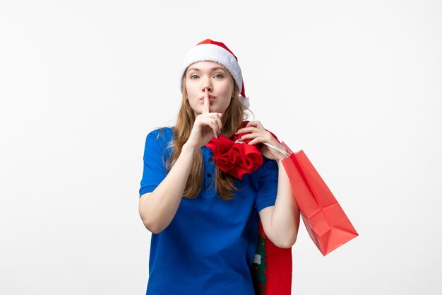 Front view of female courier holding present on a white wall