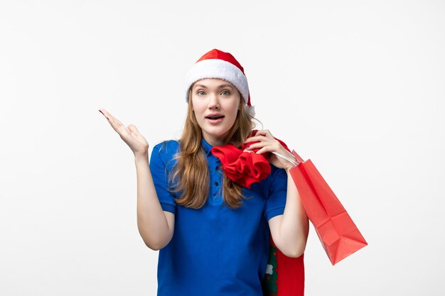 Front view of female courier holding present on the white wall